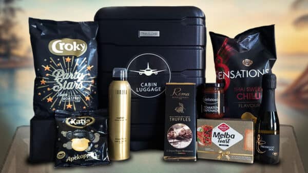 Luxe kerstpakket met zwarte reistrolley gevuld met lekkernijen, verzorgingsproducten en prosecco
