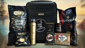 Luxe kerstpakket met zwarte reistrolley gevuld met lekkernijen, verzorgingsproducten en prosecco