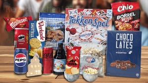 Kerstpakket met tokkenspel, led-huisje, blauwe schaaltjes, chocolade, snacks en frisdrank op een witte ondergrond