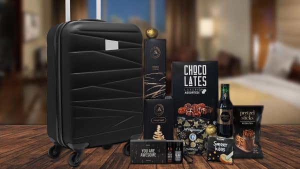 Kerstpakket met zwarte trolley, travelset, snacks, chocolade, rode wijn en geschenkdoos