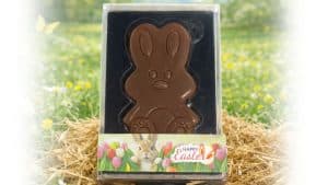 Melkchocolade paashaas in transparante verpakking met bedrukte Happy Easter wikkel