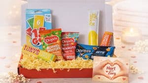 Dag van de Zorg zonnig genieten brievenbuspakket met snacks, kaartspel en hart voor de zorg kaartje