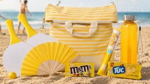 Geel zomerpakket strand met strandtas, drinkfles, snacks en beachgames in zand