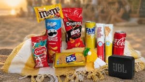 Zomerpakket met JBL speaker, snacks en drank op strand met strandtent