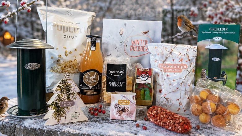 Vogelvriendelijk Wintertuin Kerstpakket met vogelvoedersilo en winterse lekkernijen in besneeuwde tuin