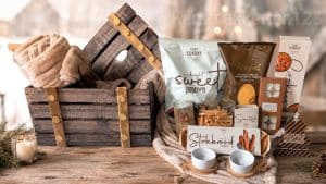 Landelijk houten opbergkist kerstpakket met zacht plaid en luxe winterse lekkernijen.
